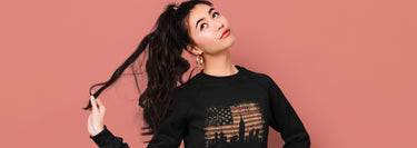 Woman wearing a unisex sweatshirt with the design of the Americas flag on it.