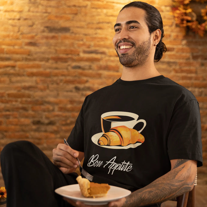 Man wearing a unisex t-shirt with a coffee and croissant design