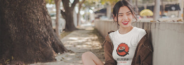 A girl wearing a white t-shirt with a painted sushi design and the phrase "I Love Sushi" written above or below the artwork.