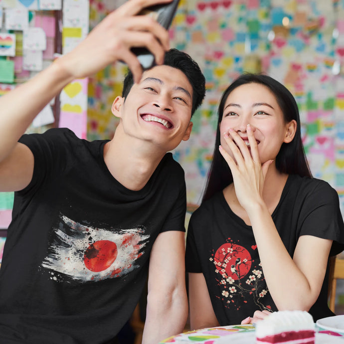 Man and woman wearing t-shirts with traditional Japanese designs, featuring elements like cherry blossoms, koi fish, or waves in vibrant, detailed patterns.